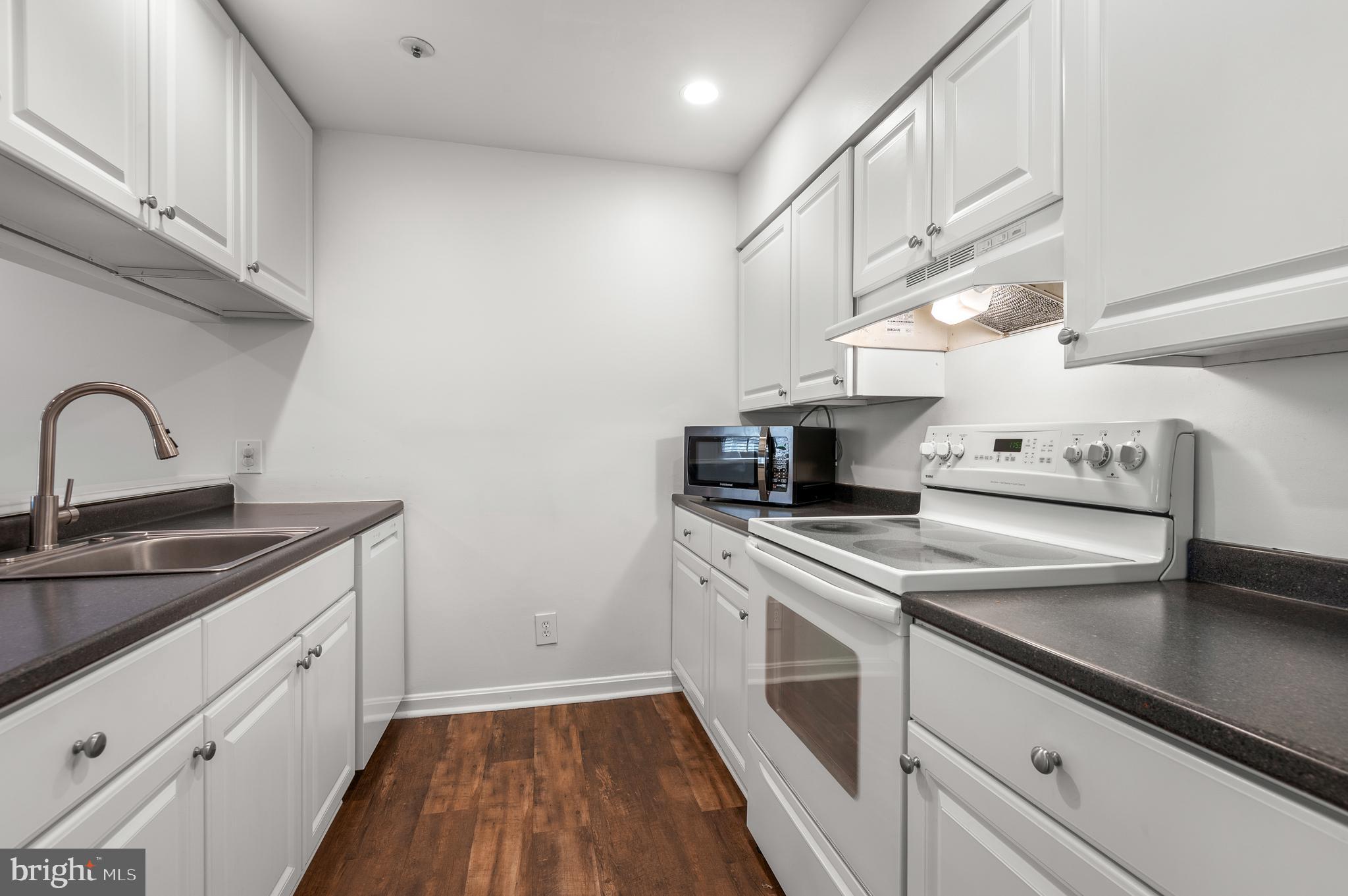 4942 Columbia Road, Unit 5 37 Columbia, MD 21044 - Photo 9 of 36 a kitchen with granite countertop a sink stainless steel appliances and cabinets
