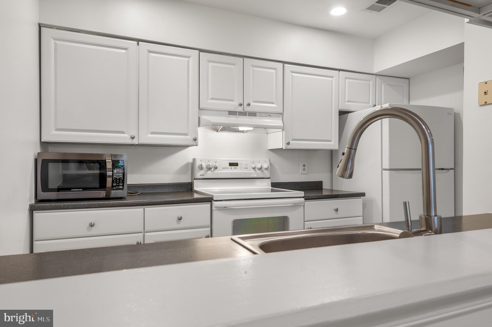 4942 Columbia Road, Unit 5 37 Columbia, MD 21044 - Photo 10 of 36 a kitchen with granite countertop white cabinets and stainless steel appliances