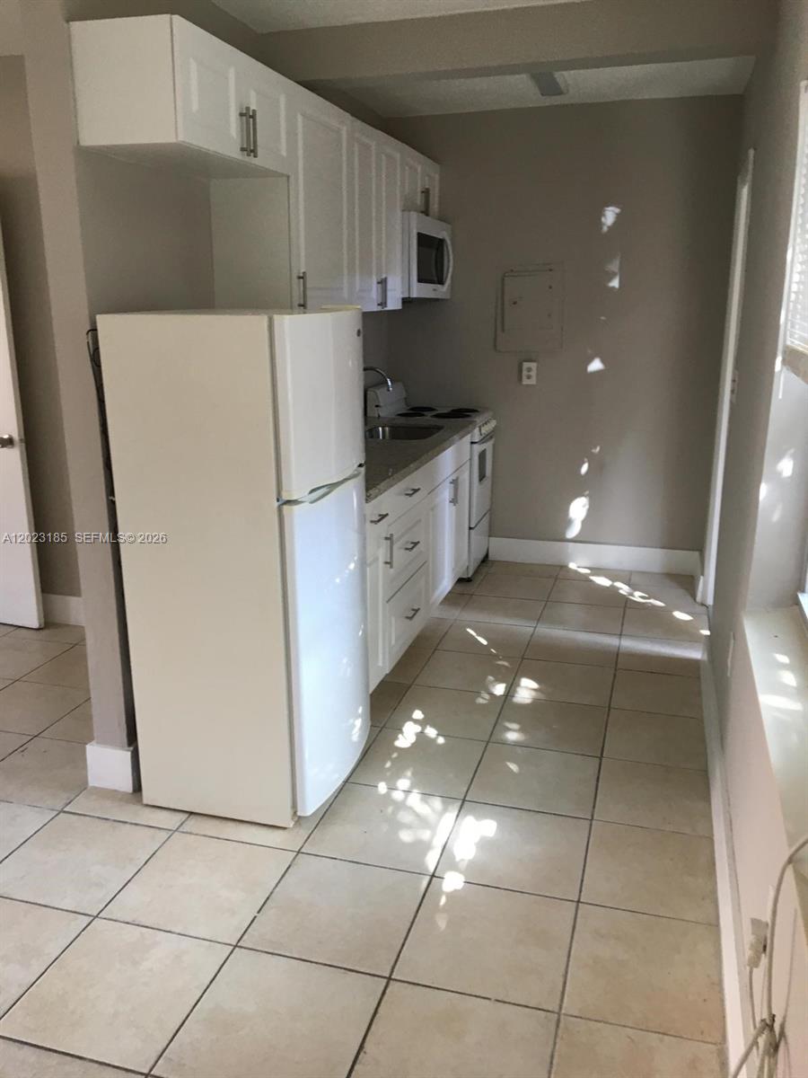 520 Southwest 4th Street, Unit 4 Miami, FL 33130 - Photo 4 of 12 a kitchen with a sink a refrigerator and a stove
