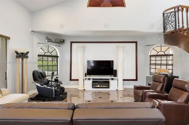 a living room with furniture a flat screen tv and a large window