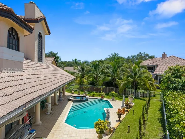 an aerial view of residential houses with outdoor space and trees