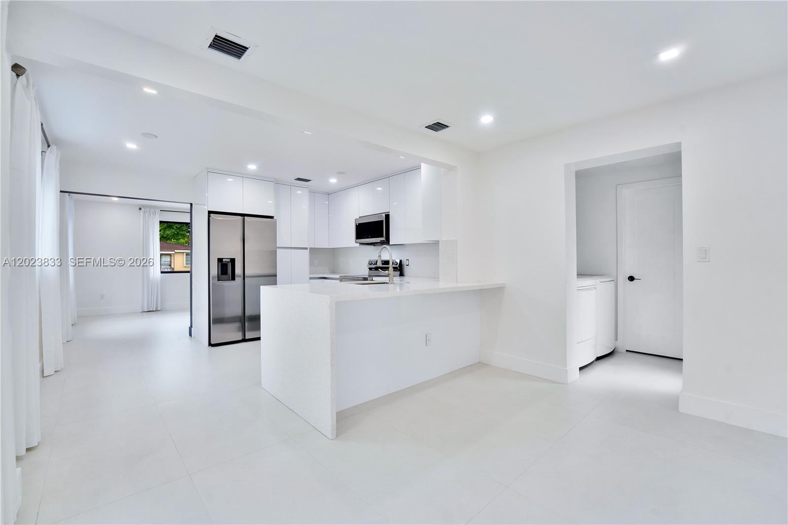 6566 Southwest 35th Street Miami, FL 33155 - Photo 11 of 36 a view of a kitchen with refrigerator and white cabinets