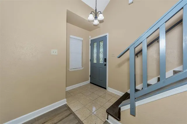 an empty room with wooden floor a ceiling fan a fireplace and windows