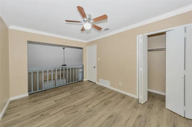 a view of a hallway with wooden floor and staircase
