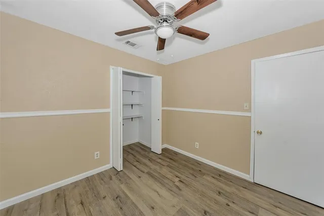 a view of room with hardwood floor and ceiling fan