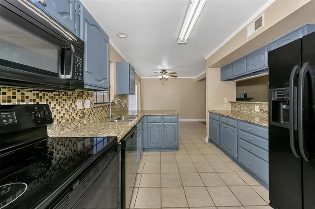 a large kitchen with kitchen island granite countertop a large counter top and wooden cabinets