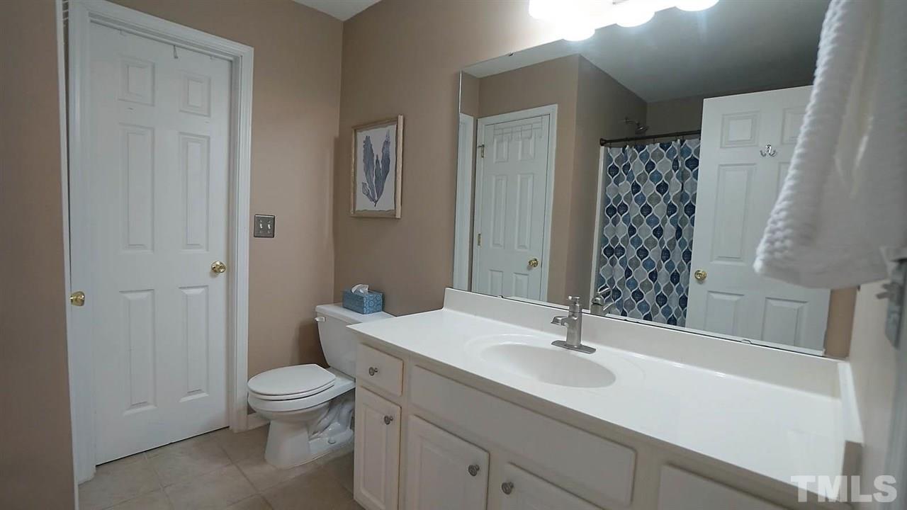 8900 Shallcross Way Raleigh, NC 27617 - Photo 13 of 22 a bathroom with a sink a toilet and shower