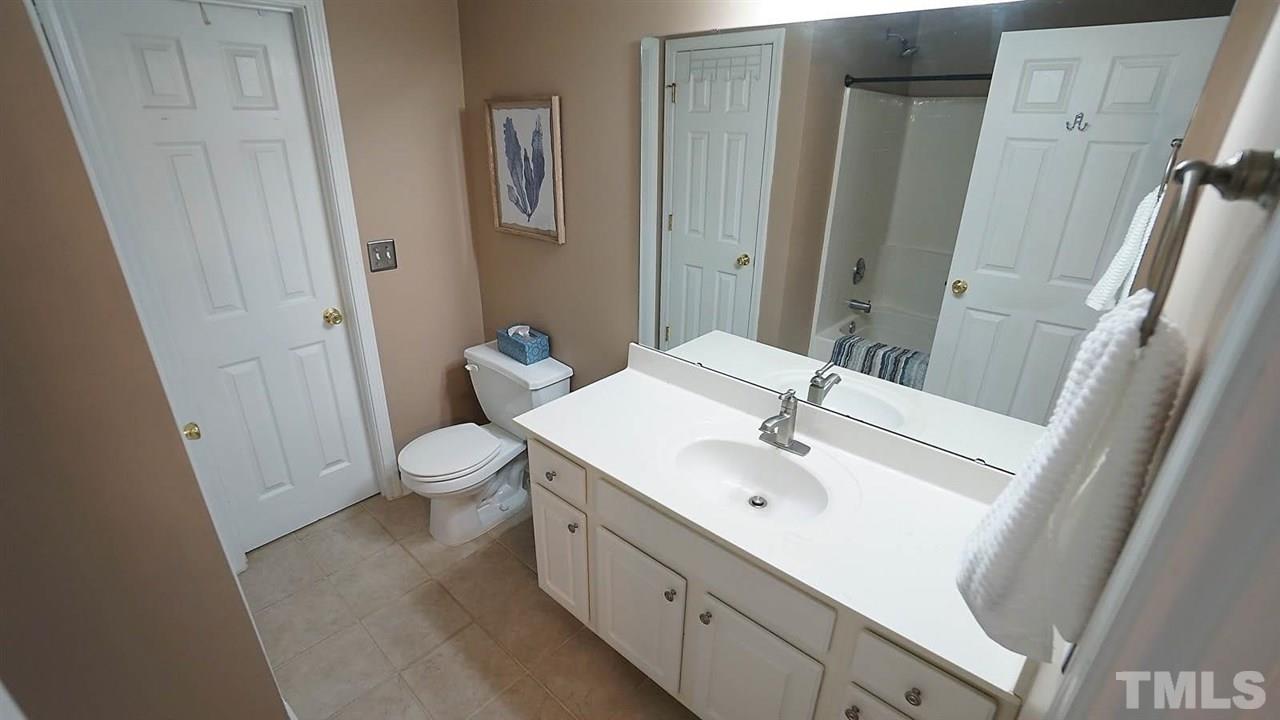 8900 Shallcross Way Raleigh, NC 27617 - Photo 14 of 22 a spacious bathroom with a sink a toilet and a mirror