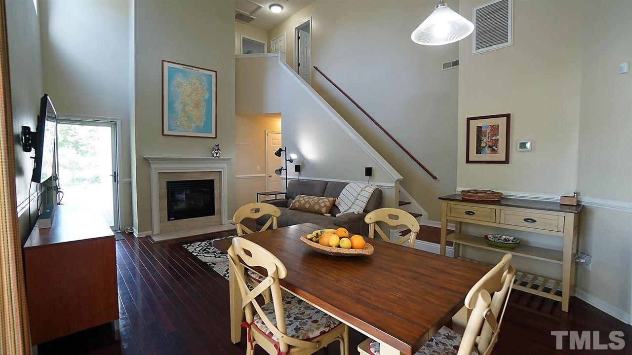 8900 Shallcross Way Raleigh, NC 27617 - Photo 6 of 22 a view of a dining room with furniture a fireplace and wooden floor