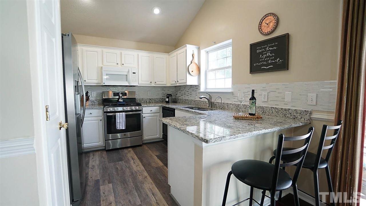 8900 Shallcross Way Raleigh, NC 27617 - Photo 7 of 22 a kitchen with a sink a stove a refrigerator and a microwave