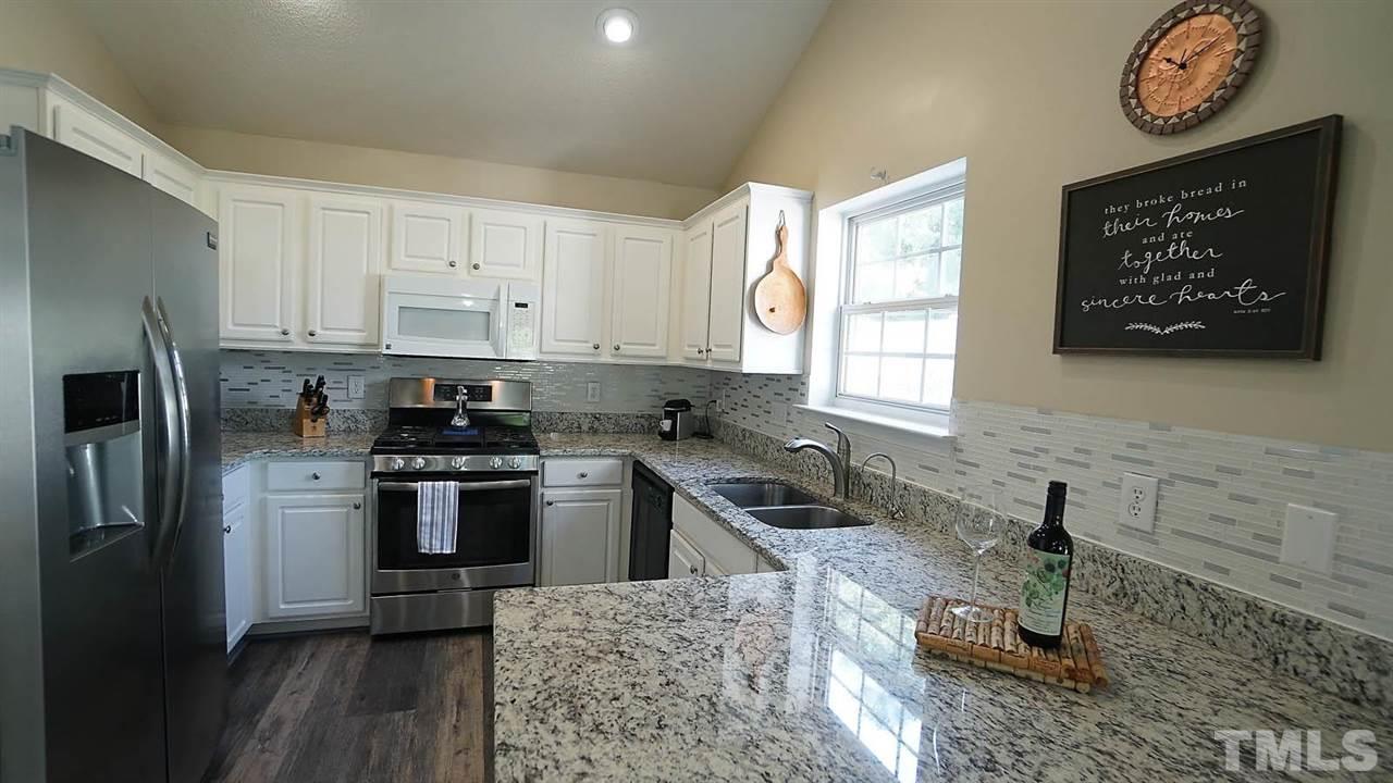 8900 Shallcross Way Raleigh, NC 27617 - Photo 8 of 22 a kitchen with stainless steel appliances granite countertop a stove a sink a refrigerator and a microwave