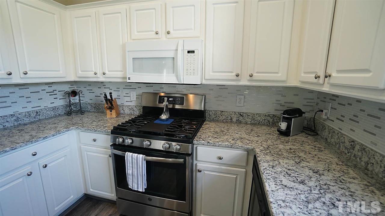 8900 Shallcross Way Raleigh, NC 27617 - Photo 9 of 22 a kitchen with granite countertop white cabinets and stainless steel appliances