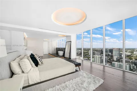 a bedroom with a bed and glass wall painting