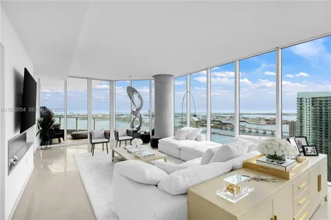 a living room with furniture large windows and a flat screen tv