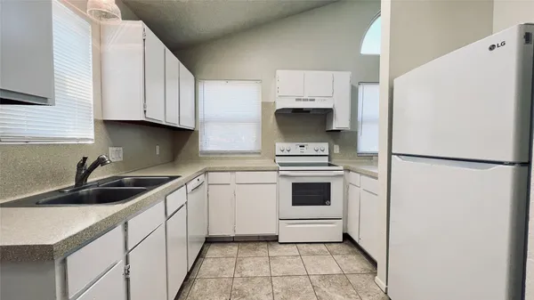 a kitchen with white cabinets and white appliances