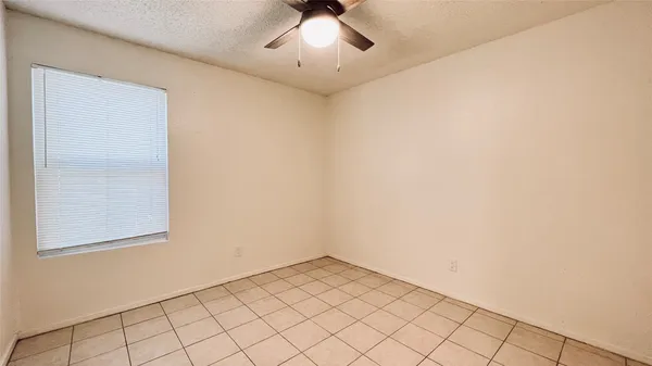an empty room with chandelier fan