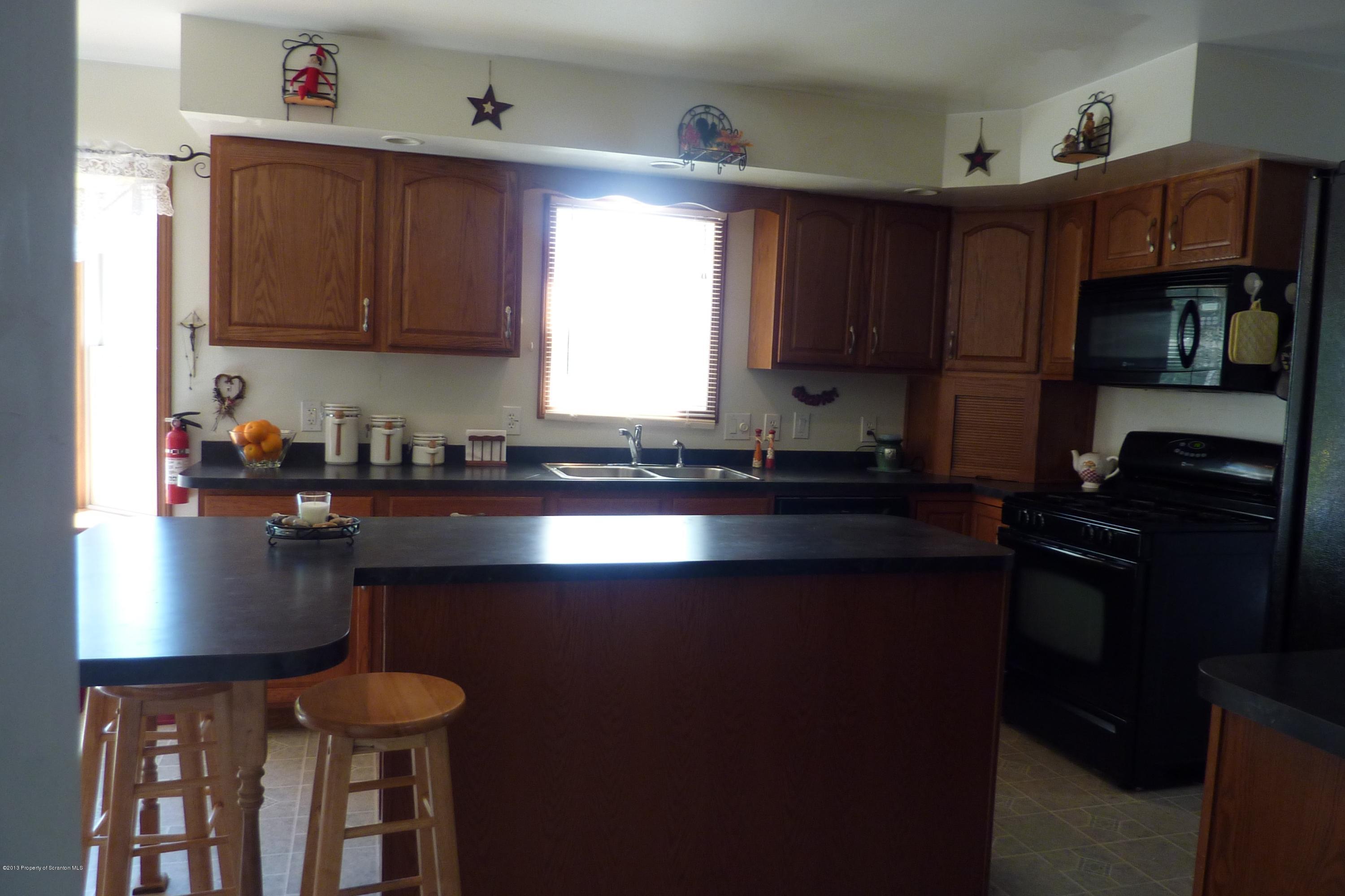 4110 Bear Brook Road Moscow, PA 18444 - Photo 5 of 31 a kitchen with granite countertop a stove a sink dishwasher and cabinets with wooden floor