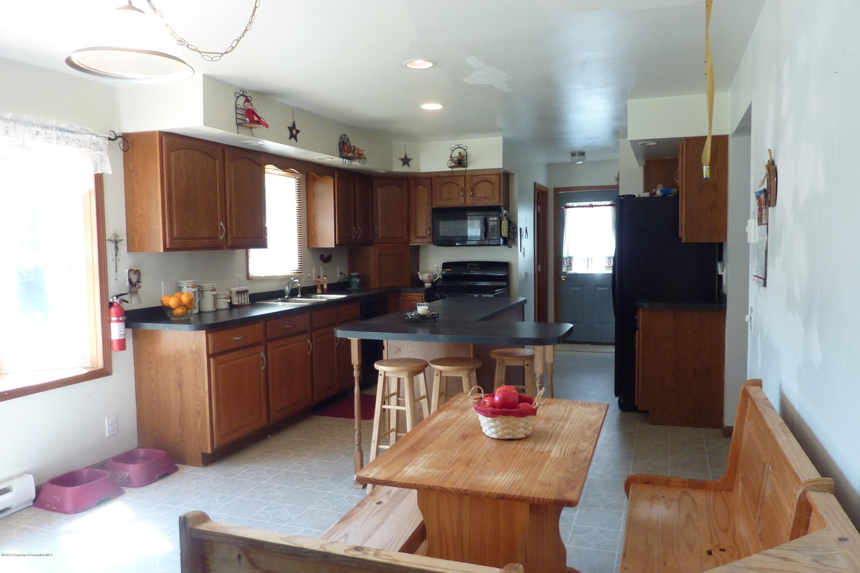 4110 Bear Brook Road Moscow, PA 18444 - Photo 6 of 31 a kitchen with stainless steel appliances granite countertop a refrigerator sink stove microwave and cabinets