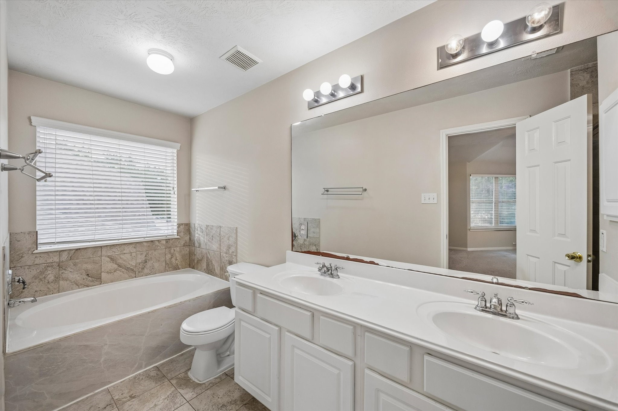 10307 Turrett Point Lane Houston, TX 77064 - Photo 7 of 12 a bathroom with a double vanity sink a toilet a bathtub and shower