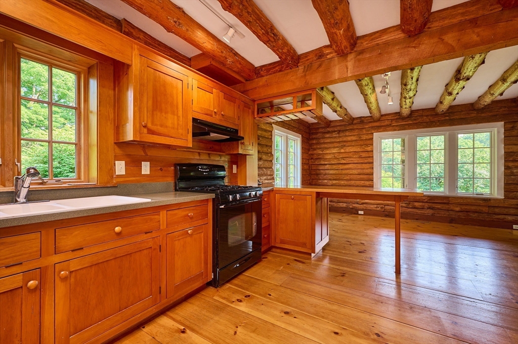 63 Montague Road Leverett, MA 01054 - Photo 11 of 42 a kitchen with stainless steel appliances granite countertop a stove a sink and a granite counter tops with a large window