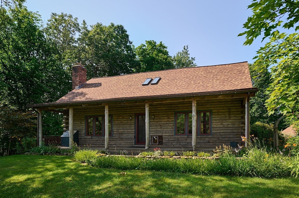 63 Montague Road Leverett, MA 01054 - Photo 2 of 42 a brick house with a small yard and a large window