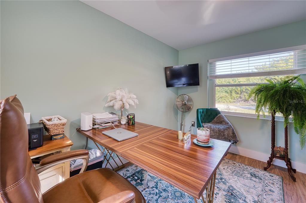 1027 Coral Ridge Drive Punta Gorda, FL 33950 - Photo 20 of 46 a living room with furniture a flat screen tv and a floor to ceiling window
