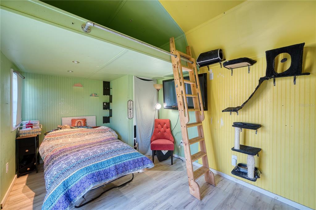 1027 Coral Ridge Drive Punta Gorda, FL 33950 - Photo 23 of 46 a bedroom with a bed and wooden floor