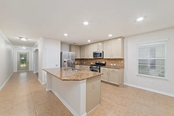 a kitchen with stainless steel appliances granite countertop a sink stove and refrigerator