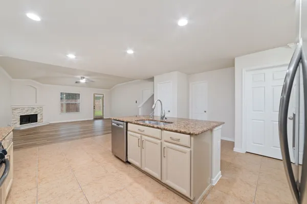 a kitchen with stainless steel appliances granite countertop a sink and a refrigerator