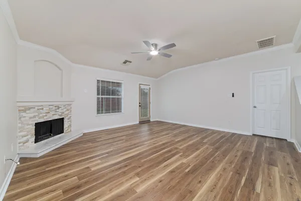 a view of empty room with wooden floor and fireplace
