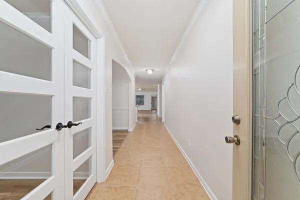 a view of a hallway with wooden floor and staircase