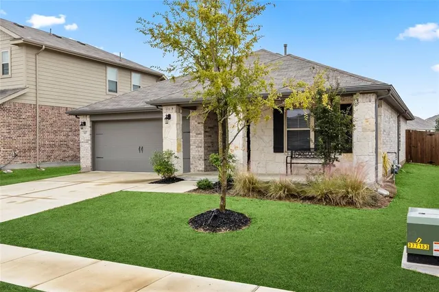 a front view of a house with a garden and plants