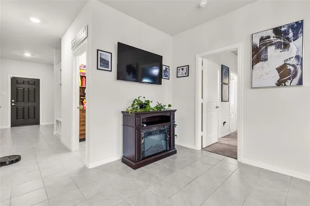 a living room with stainless steel appliances furniture a fireplace and a flat screen tv