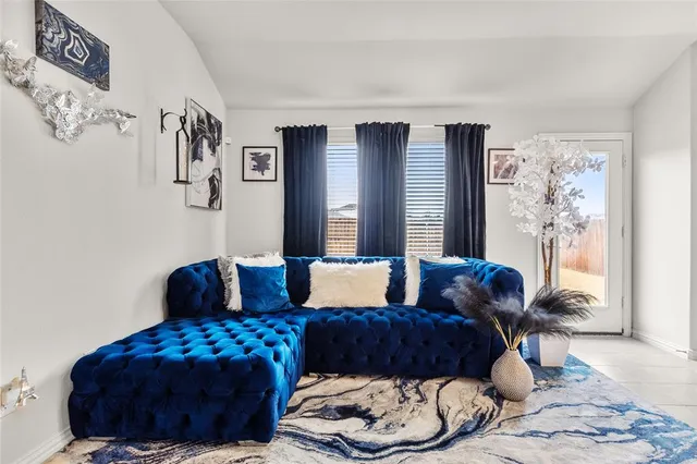 a living room with furniture and a floor to ceiling window