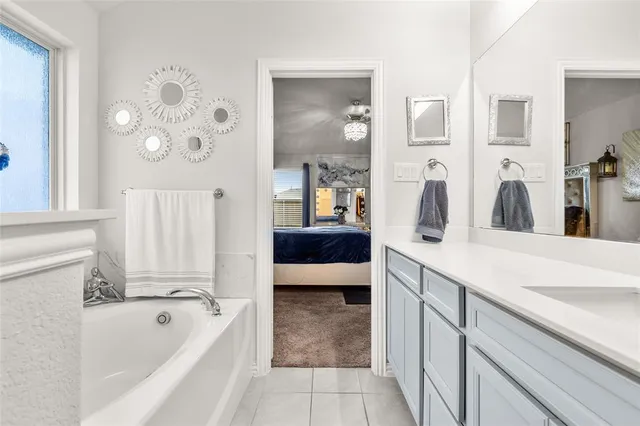 a spacious bathroom with a tub sink and mirror