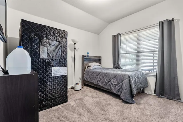 a bedroom with a bed and a painting on the wall