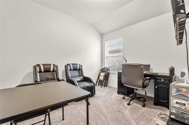 a view of a workspace with furniture and a window