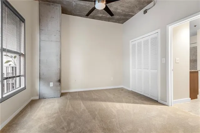 an empty room with windows and cabinet