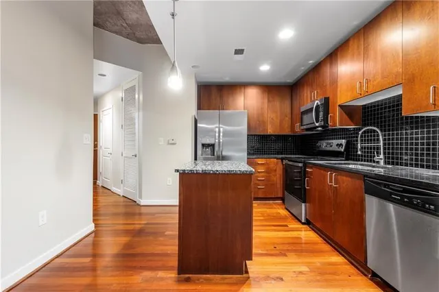 a large kitchen with stainless steel appliances granite countertop a stove a sink and a refrigerator