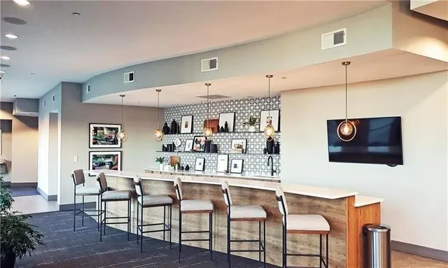 a living room with furniture kitchen view and a flat screen tv
