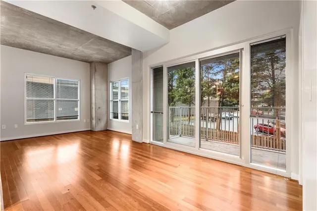 a view of empty room with wooden floor and floor to ceiling window