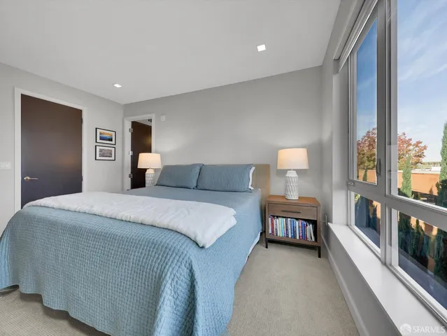 a bedroom with a large bed and a night stand