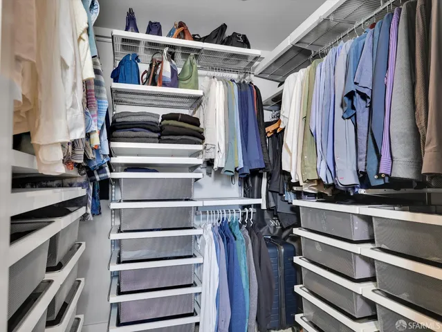 a view of walk in closet with clothes and shoes