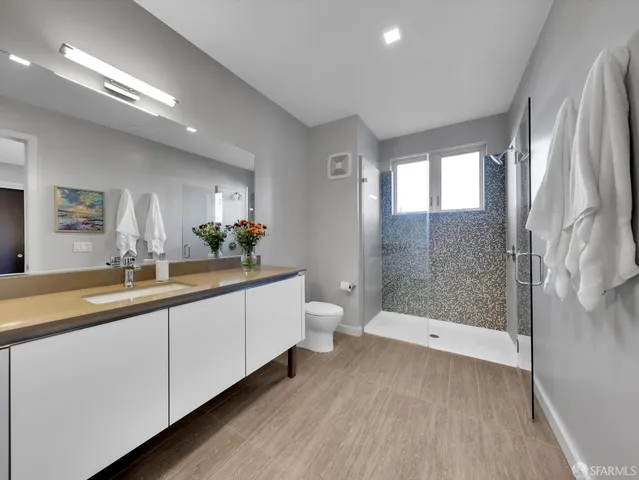 a bathroom with a double vanity sink toilet and shower