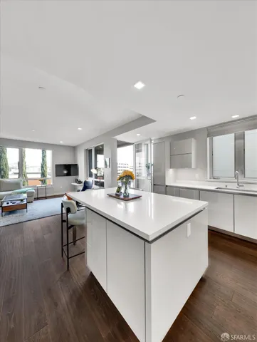 a kitchen with counter top a sink cabinets and wooden floor