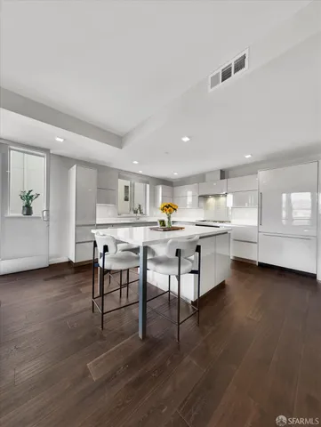 a living room with stainless steel appliances furniture and wooden floor