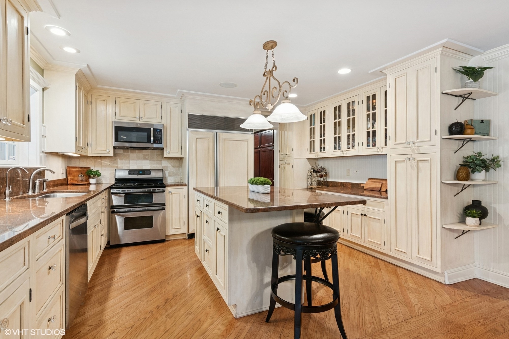 6730 South Madison Street Willowbrook, IL 60527 - Photo 16 of 52 a kitchen with granite countertop a stove a sink dishwasher a refrigerator and a dining table with wooden floor