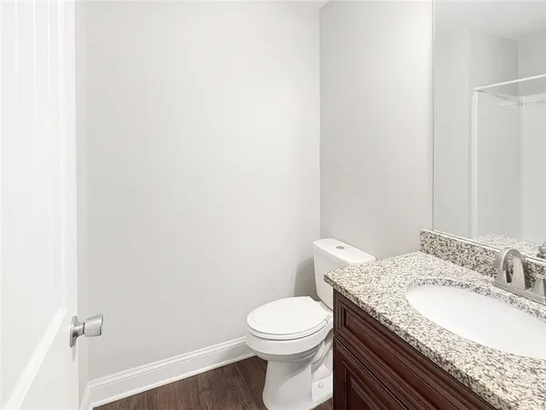 a bathroom with a granite countertop toilet and a sink