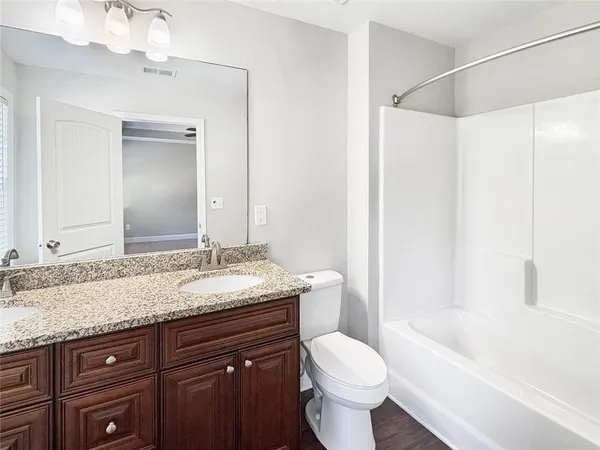 a bathroom with a granite countertop sink toilet and shower