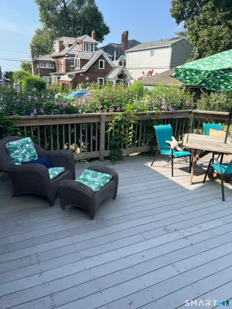 a view of a patio with couches chairs and wooden floor